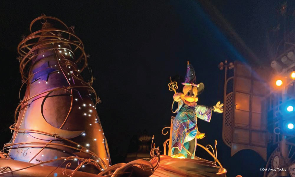 Socerer Mickey in a blue ombre outfit in a parade at disneyland