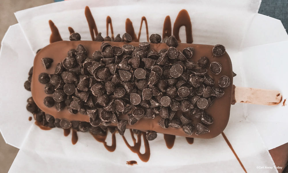 chocolate hand dipped ice cream bar with chocolate chips on top