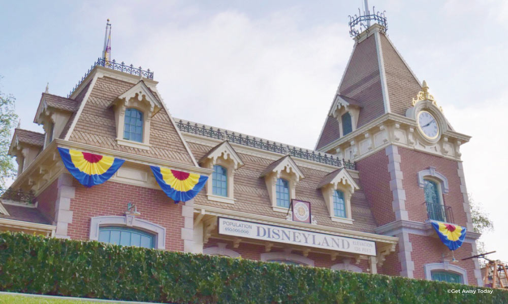 Disneyland Main Street Railroad Station with Disneyland sign and colorful banners