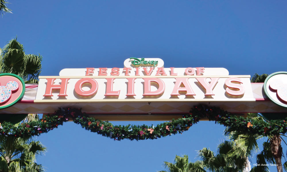 Disney Festival of Holidays Sign surrounded by garland