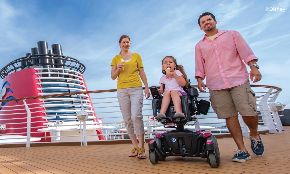 Family with daughter in a wheelchair eating ice cream on the ship deck.