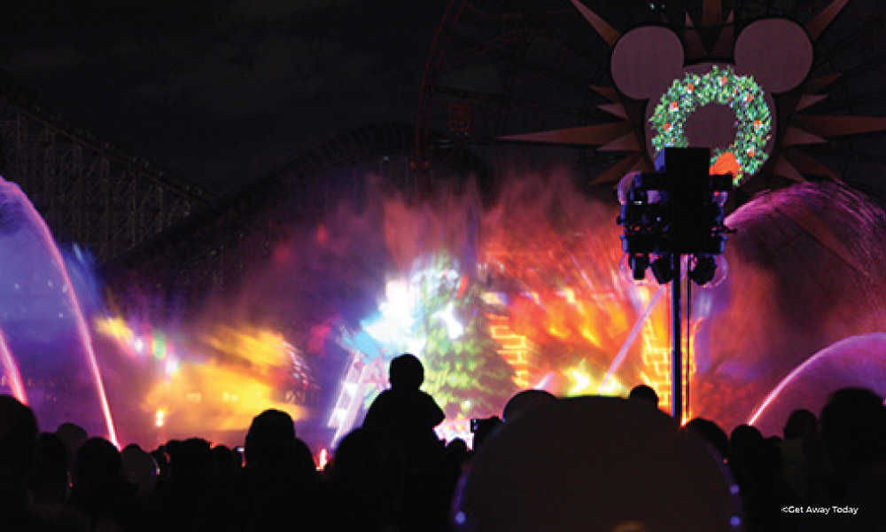 World of Color - Season of Light projections with a shadow of a child on their parent's shoulders