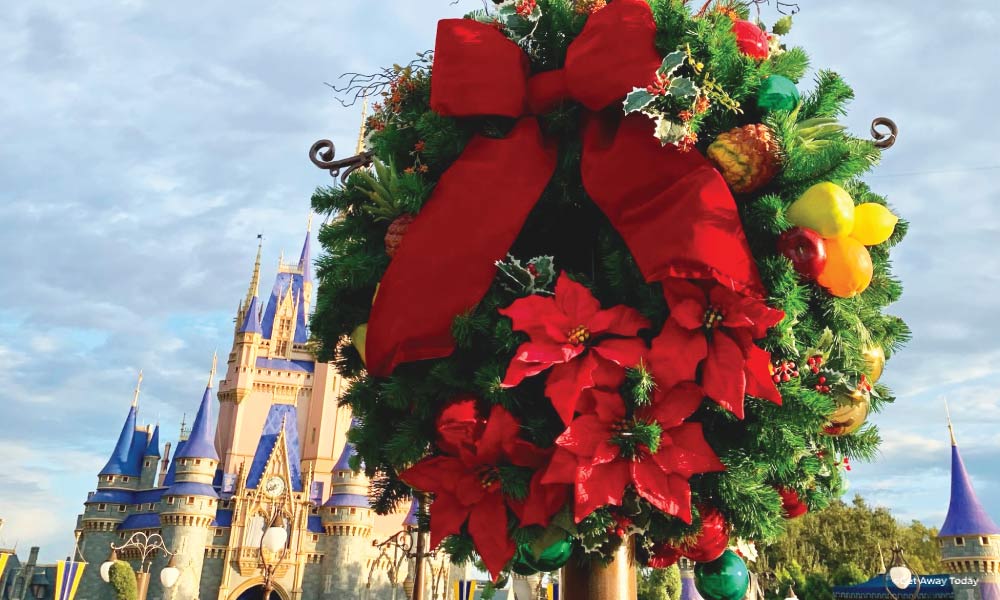 Holiday wreath with poinsetta and a red bow on a lightpost at Disney World