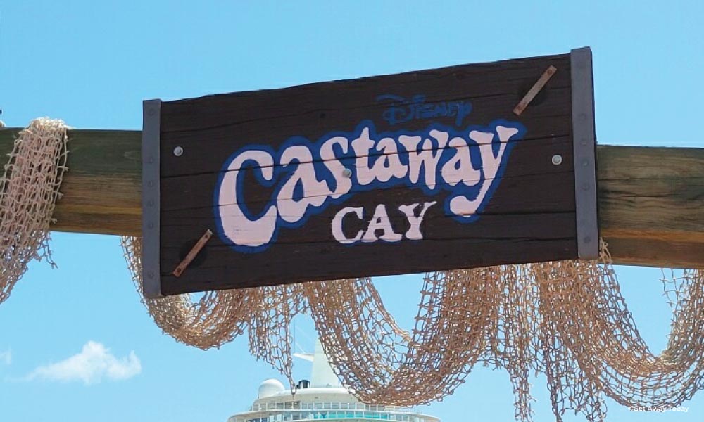 Wooden sign with white bold letters saying Castaway Cay with netting around it