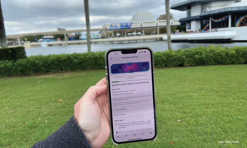 Phone being held up showing a Virtual Queue on the Disney World App