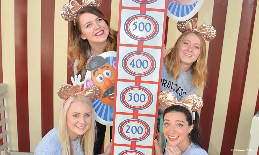 Friends in matching shirts and minnie ears posing near Toy Story Midway Mania!