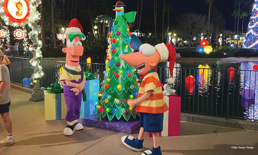 Phineas and Ferb in front of a Christmas tree with Perry the Platypus on top