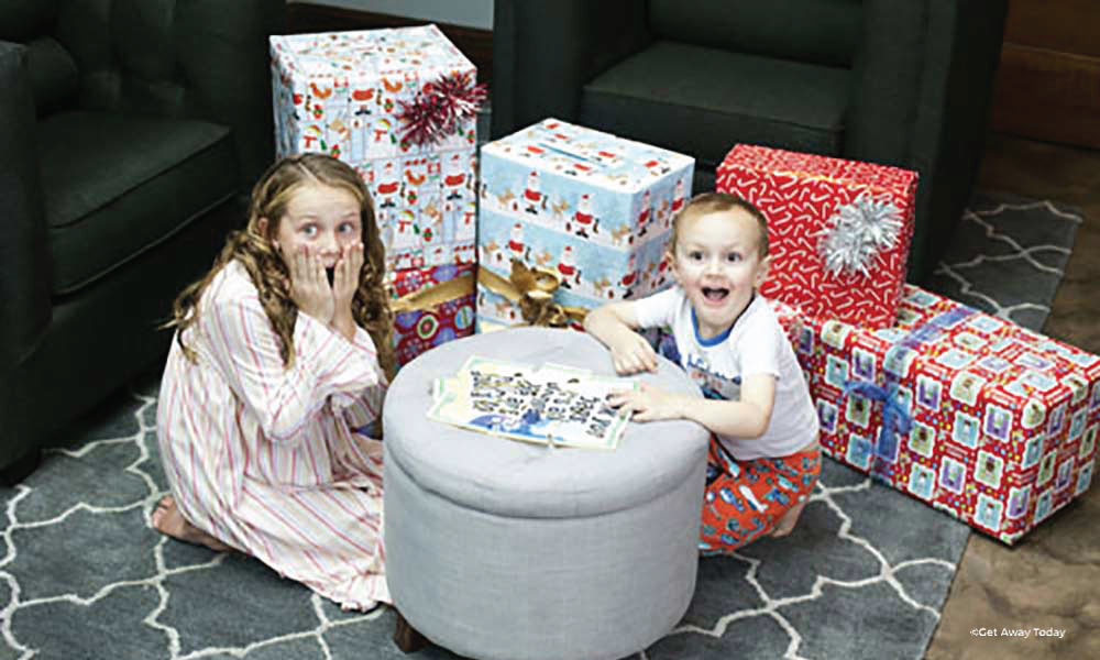 Kids with a finished puzzle on an ottoman looking surprised