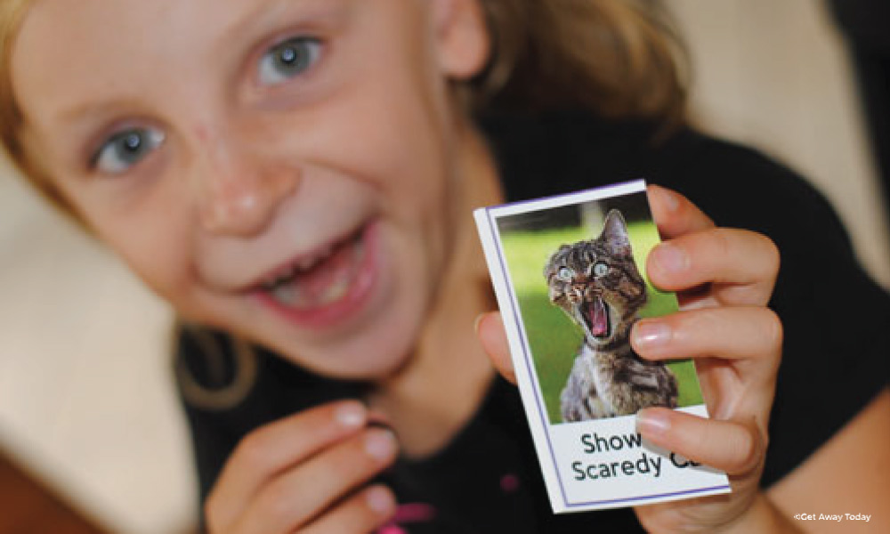 child girl showing a card with a cat screaming 