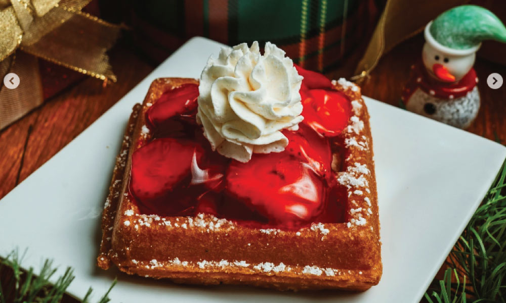 Waffle with strawberries, glaze and whipped cream