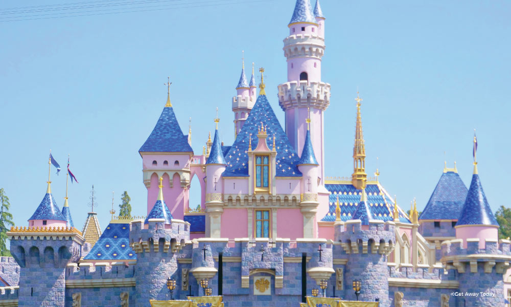 Pink and blue castle at Disneyland with blue sky