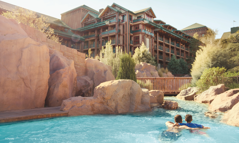 Father and son in a pool at Disney's Wilderness Lodge looking at the hotel surrounded by rocks