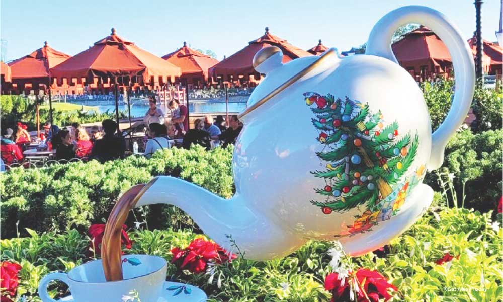 Giant tea pot with christmas tree on the side of it pouring fake tea