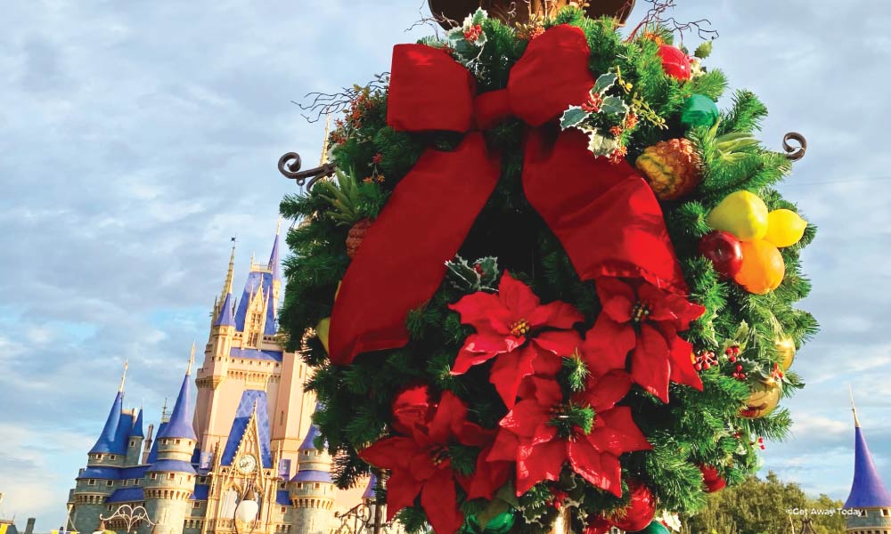 Wreath with Poinsettia and red bow with Cinderella Castle in the background