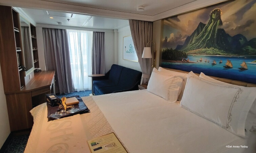 Disney Cruise Line Stateroom with bed and art of Moana over the bed