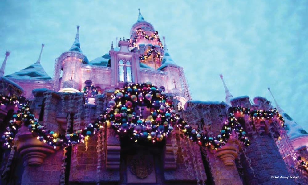 Sleeping Beauty Castle during Christmas with garland and a wreath at Disneyland at night