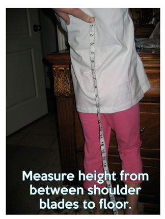 Measuring the length of a child's shoulderblades to the ground with a flexible measuring tape