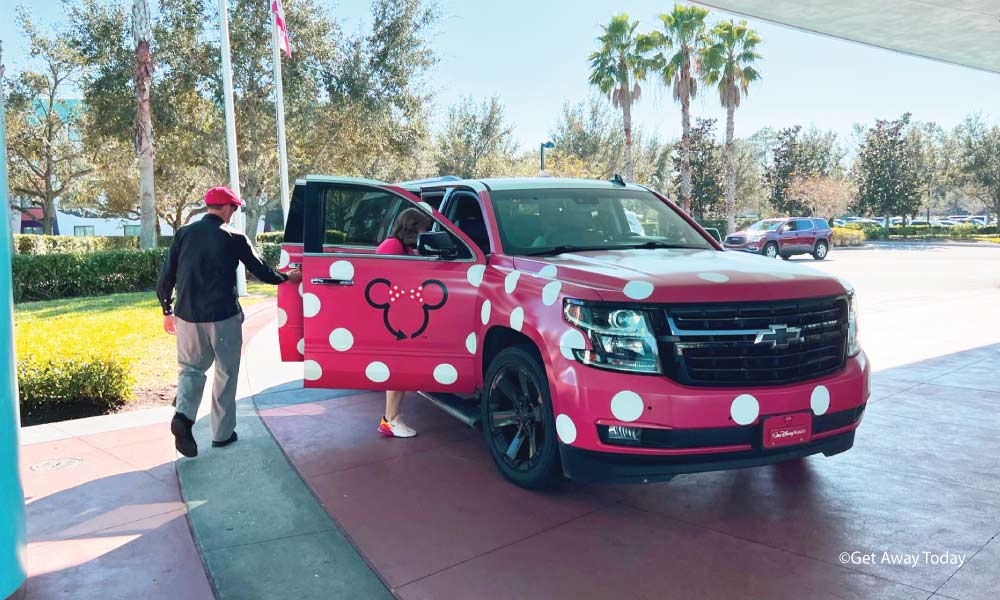 Red SUV with white dots and a Minnie Mouse silhouette on the open passenger door