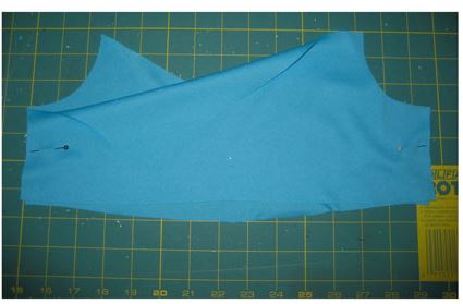 Pinning two blue pieces of fabirc together to make a bodice