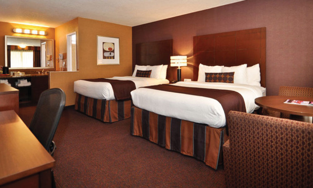 Best Western Stovalls Room featuring brown and white bedding and brown walls