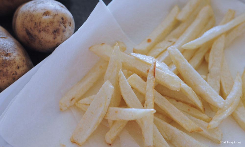 Freshly fried fries on a paper towel to dab the grease