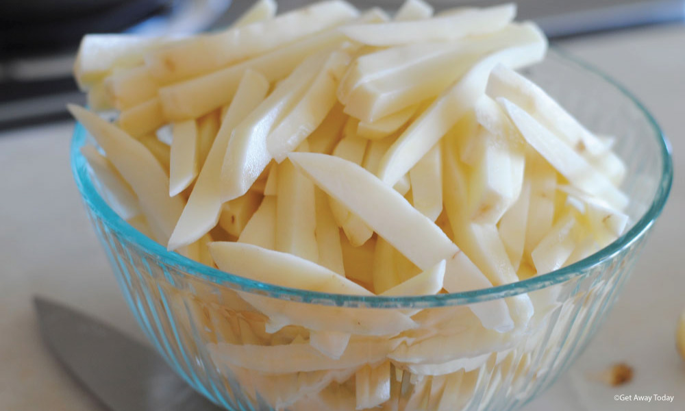 Peeled potatoes cut into thick fries