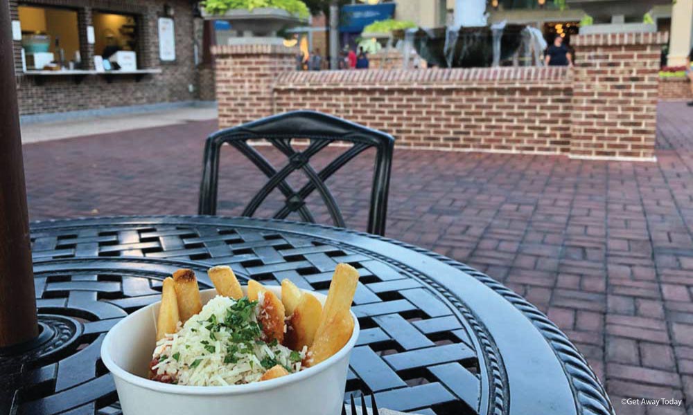 Cup of Poutine on a metal table at Disney Springs in Orlando