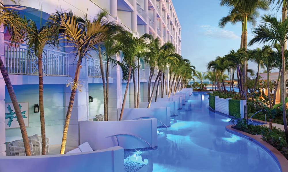 long skinny pool that connects to swim-out rooms at a resort