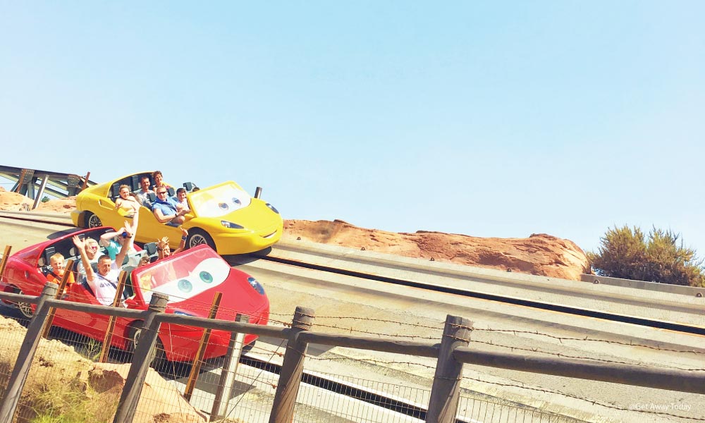 A red and yellow car racing each other on Radiator Springs Racers