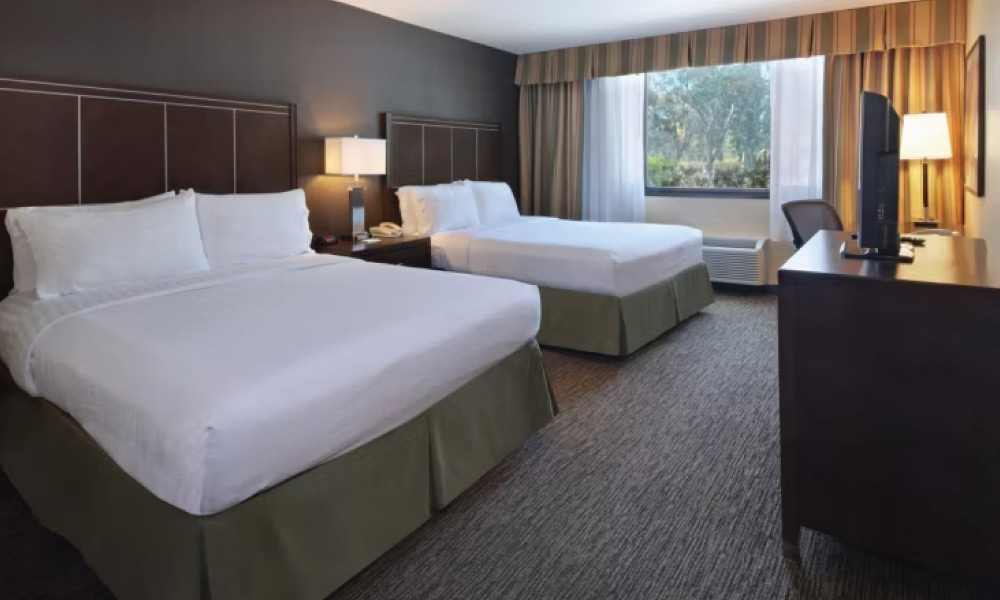 Hotel room with two beds that have white bedding