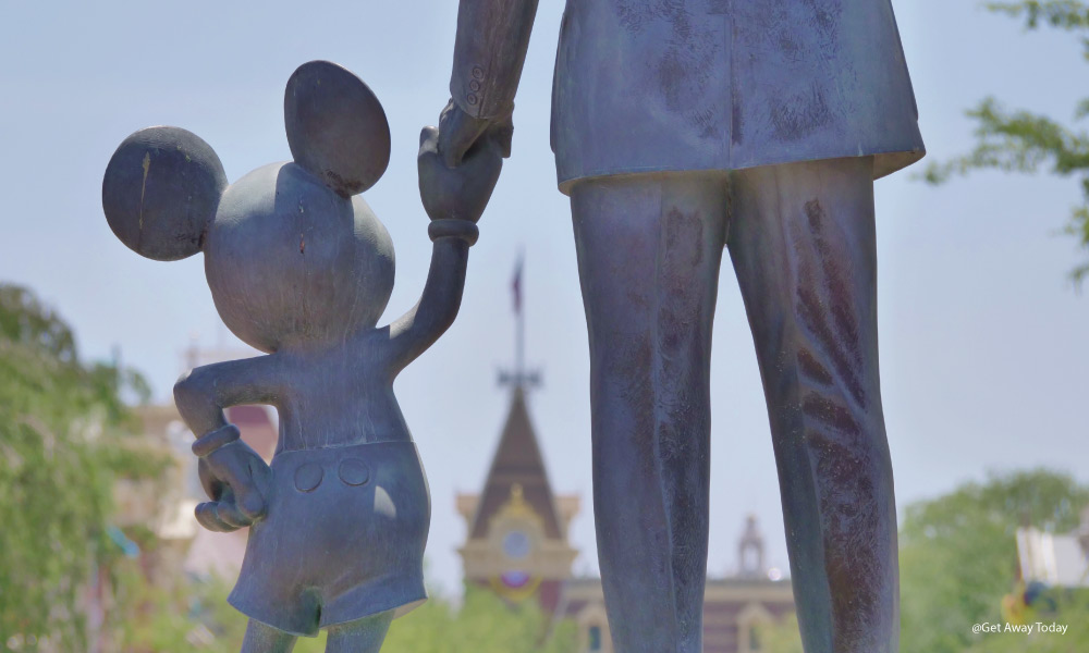 statue of mickey mouse holding walt disney's hand